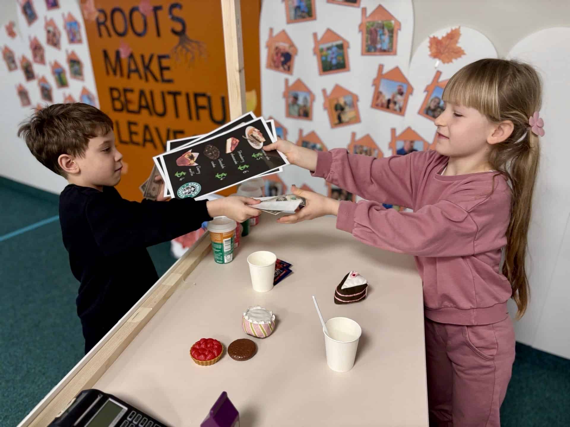 doi copii care invata la cursurile de engleza cum sa ceara un ceai intr-o cafenea